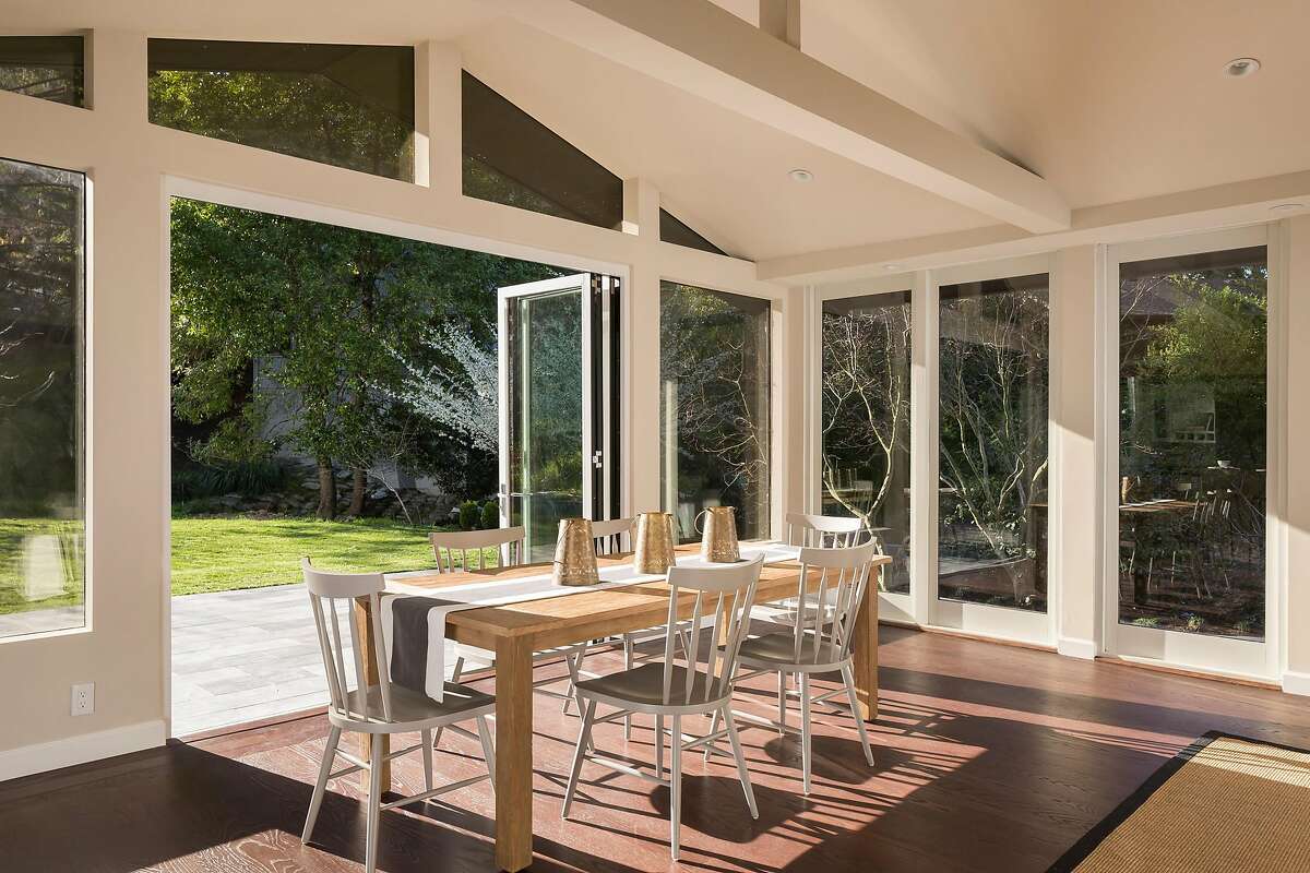 Collapsible glass doors off the dining room reveal a level lawn in the backyard.