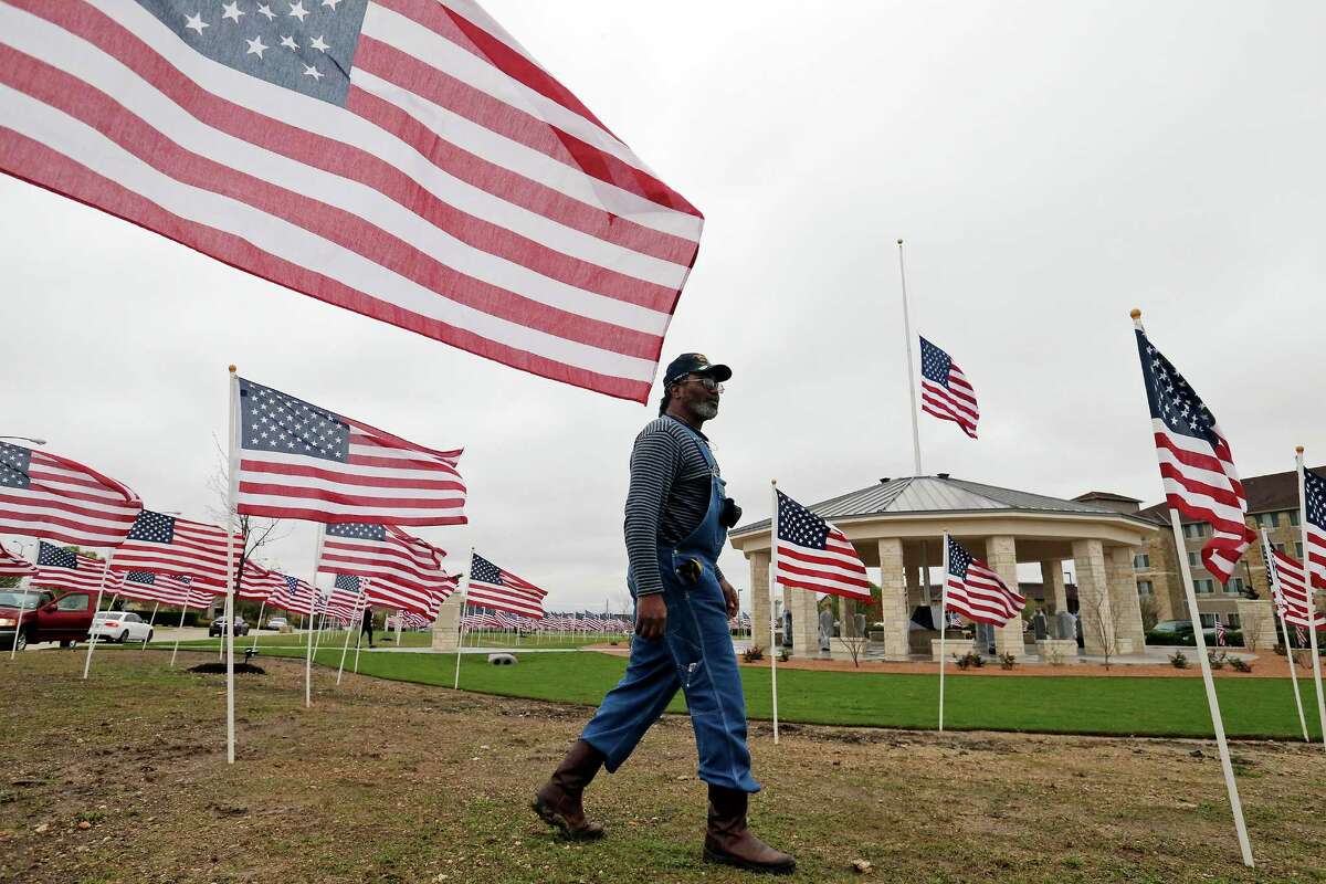 Mark Hyde, a member of the Exchange Club of Killeen, checks on the 490 American flags placed around the Fort Hood November 5 Memorial (rear) Thursday March 10, 2016 at the Killeen Civic and Conference Center in Killeen, Tx. The memorial to the 13 people killed and 31 wounded Nov. 5, 2009 by gunman Army psychiatrist Nidal Hasan will be dedicated Friday March 11, 2016. Texas Gov. Greg Abbott will present Texas Purple Heart medals to family members of the deceased and to the wounded survivors.