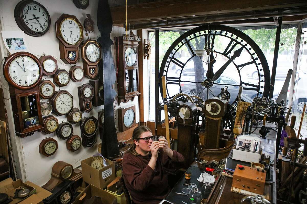 Clock-maker's apprentice Maxwell Nesbet, fixes a pocket watch at his desk at Dorian Clair's clock repair shop in Noe Valley, San Francisco, California, on Friday, March 11, 2016. Maxwell may be helping Dorian Clair reset the time on the Ferry Building clock this year for daylight savings.