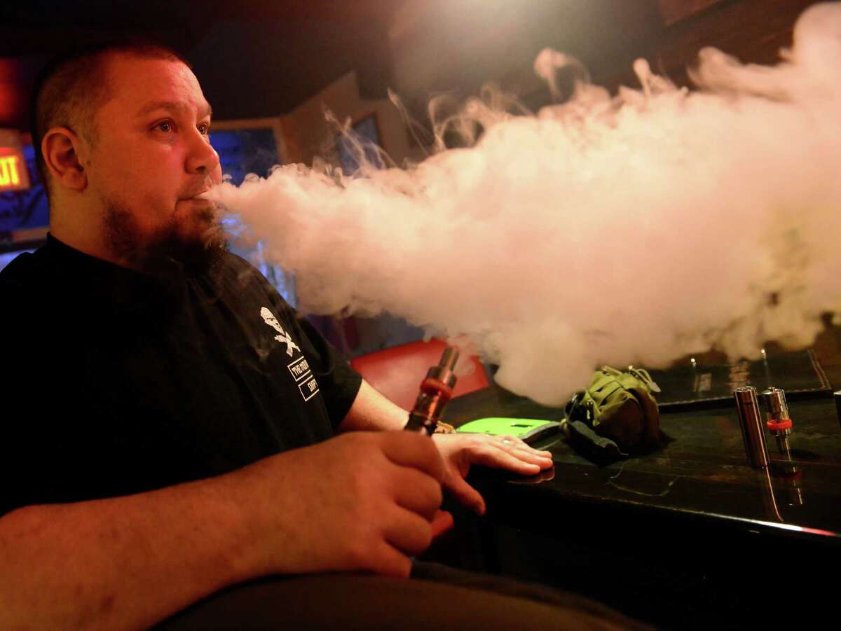 Bruce Belisle vapes at The Mod House Vapor Emporium on River Street in Milford, Conn. The Ansonia Board of Aldermen decidede not to include vaping in a ban prohibiting smoking and chewing tobacco products in the city’s parks, recreational sites and athletic fields.