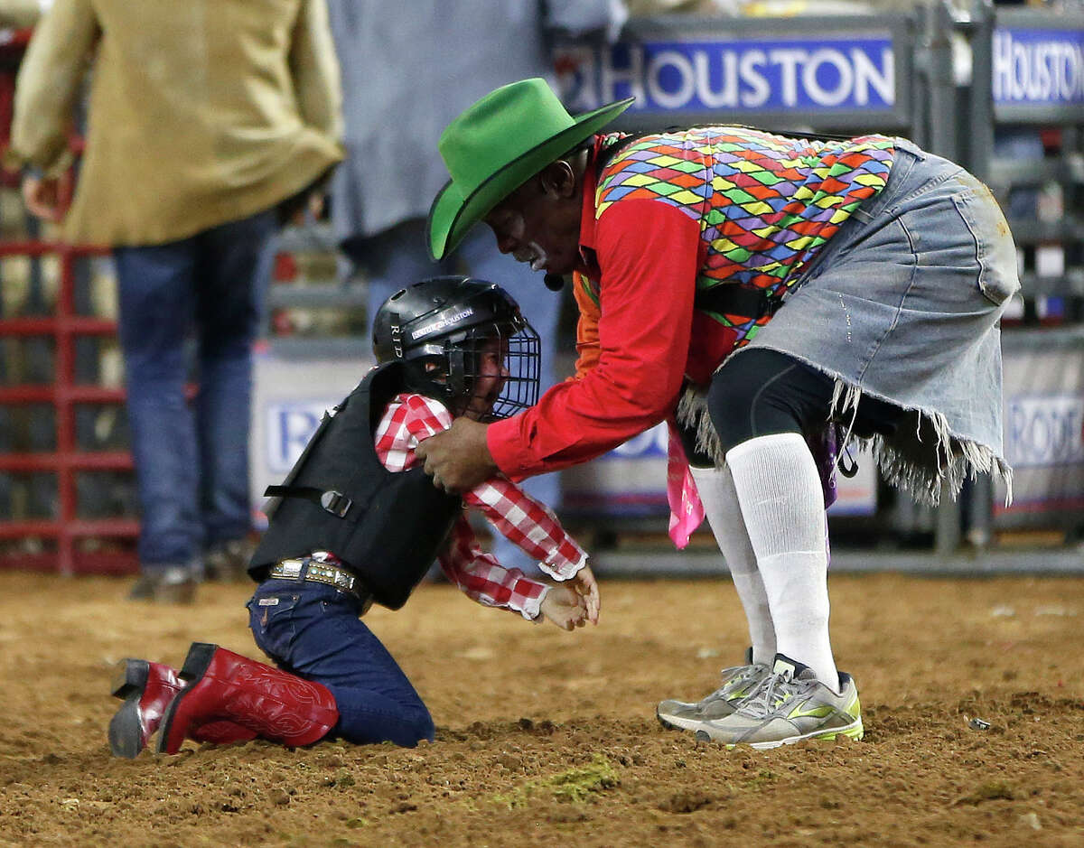 Coffee, picks up a child bucked off a sheep during the Mutton Bustin' event Thursday, March 10.