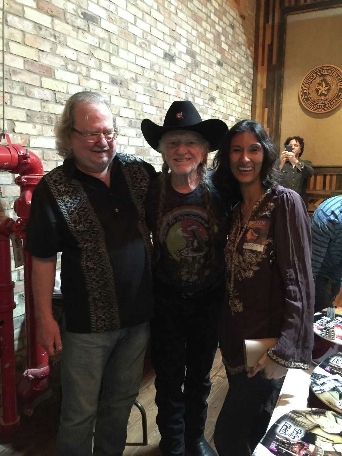 Immunologist James Allison and wife, Dr. Padmanee Sharma, with singer Willie Nelson after Allison joined him on stage to play harmonica for one of the "top five moments" of his life.