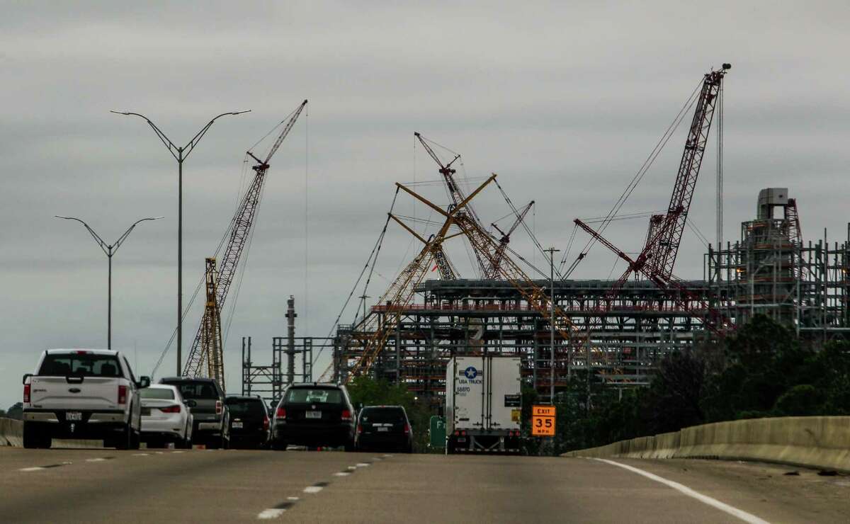 Cranes at the Chevron Phillips refinery reach above the trees off I-10 Thursday, March 10, 2016 in Baytown. ( Michael Ciaglo / Houston Chronicle )
