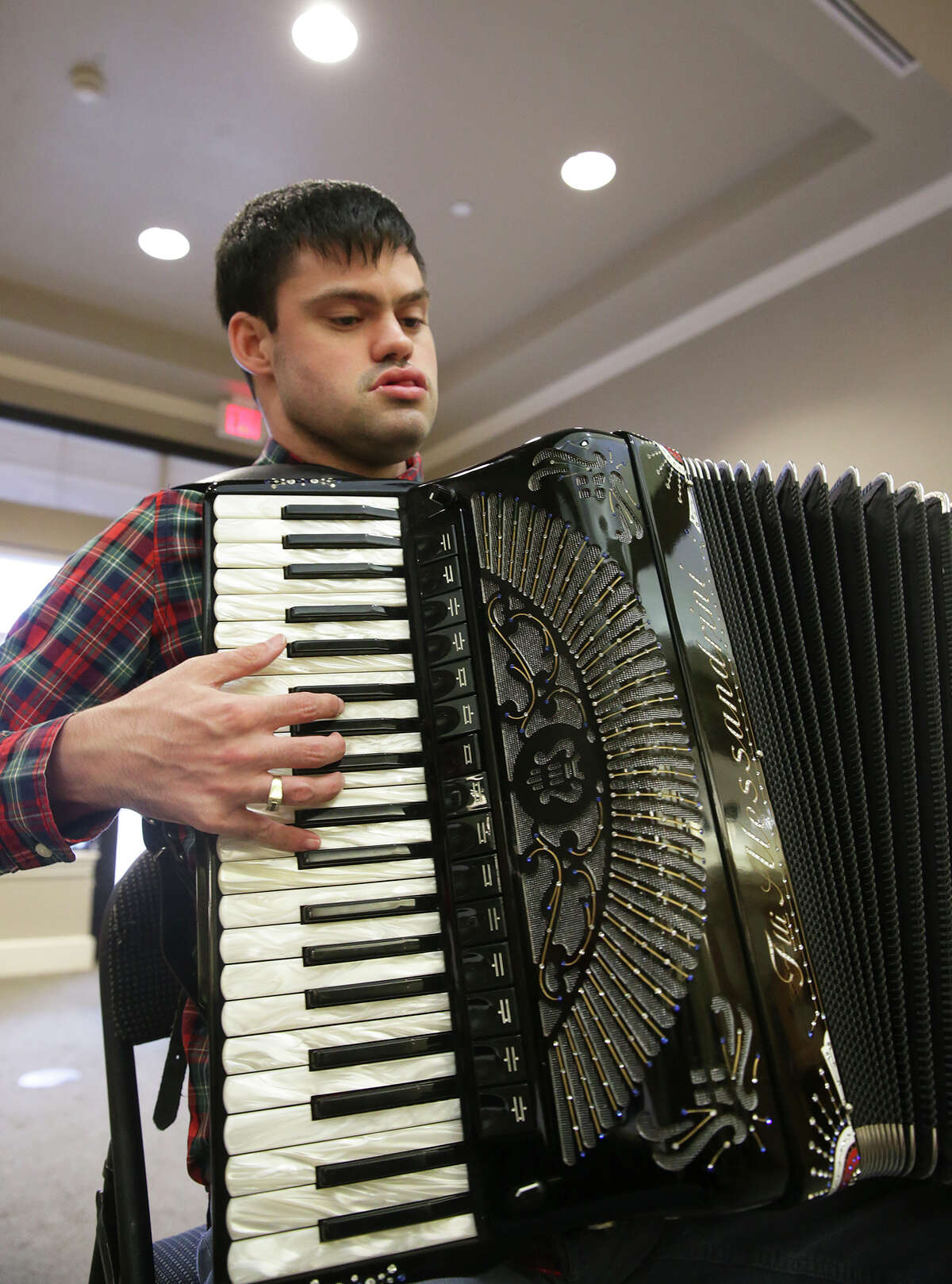 John McDonald, who has the developmental disorder Asperger's syndrome, which affects his ability to socialize and communicate effectively, performs a song on the accordion at the Kendall House Retirement Home in Boerne on Wednesday. McDonald is a good example of what autism experts advise all parents of autistic kids to do: Identify and cultivate their child’s special interests and talents as early as possible to improve the odds they’ll be able to make their own way in the world.