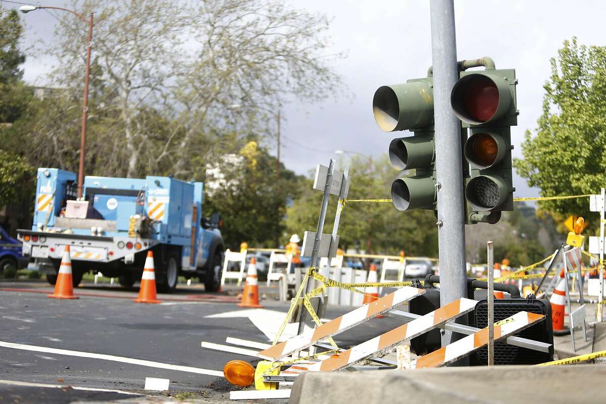 A traffic light protrudes from a sinkhole at the intersection of Rheem Boulevard and Center Street on Monday, March 14, 2016 in Moraga, California.