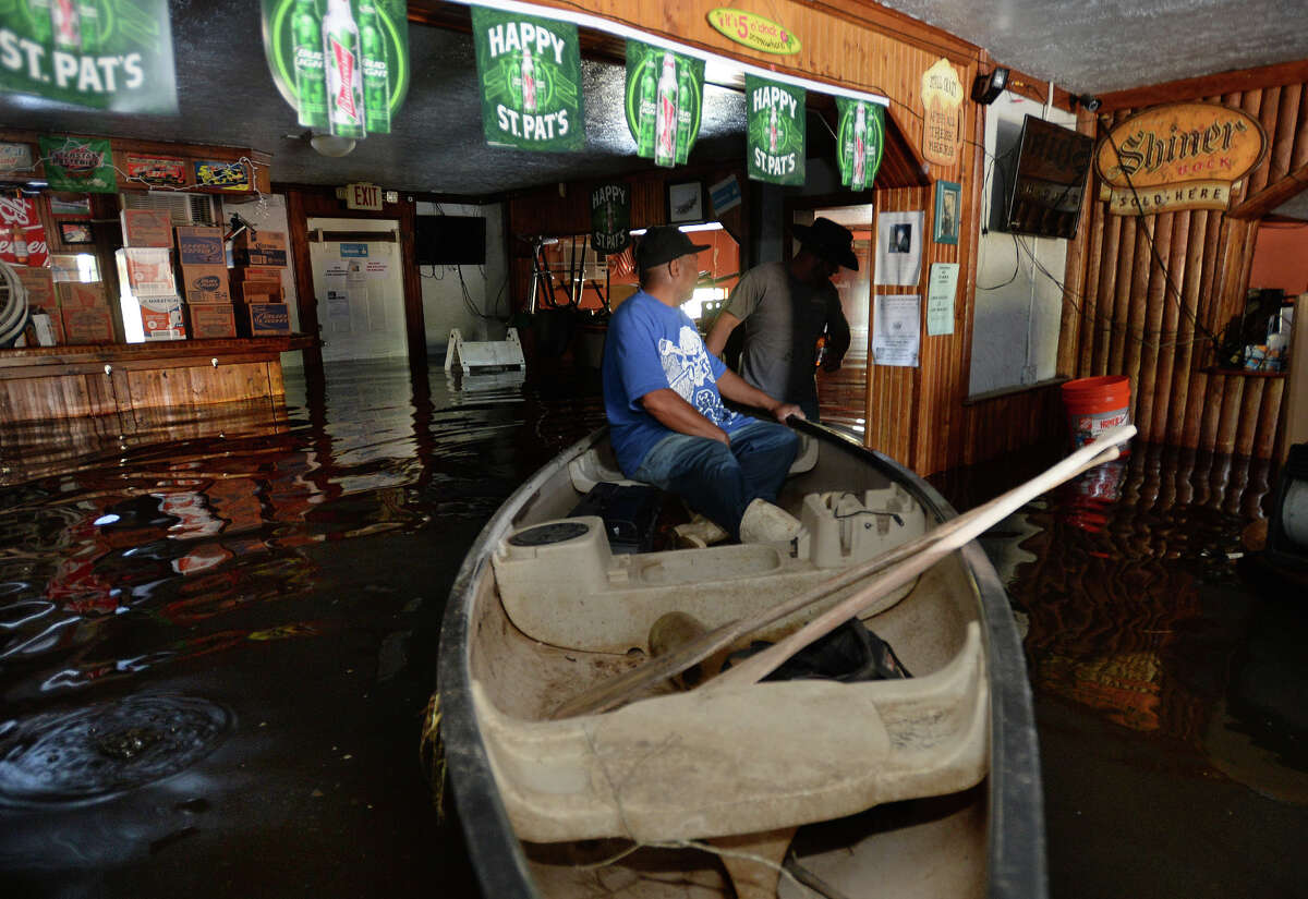 James Sparkman pulls Gerald Evans in a canoe through the flooded Bayou Club in Orange on Monday. Tasked with removing a jukebox, Evans used the canoe to get to the jukebox. Water from the nearby Bayou rose early Monday morning due to last week's rain. Photo taken Monday, March 14, 2016 Guiseppe Barranco/The Enterprise