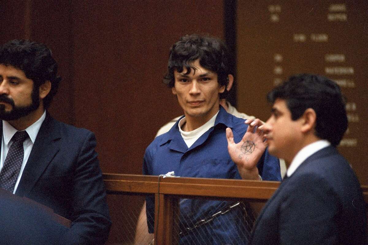 "Night Stalker" defendant Richard Ramirez displays a pentagram symbol on his hand inside a Los Angeles courtroom Thursday, Oct. 24, 1985. Ramirez plead not guilty to 68 felonies, including 14 counts of murder.