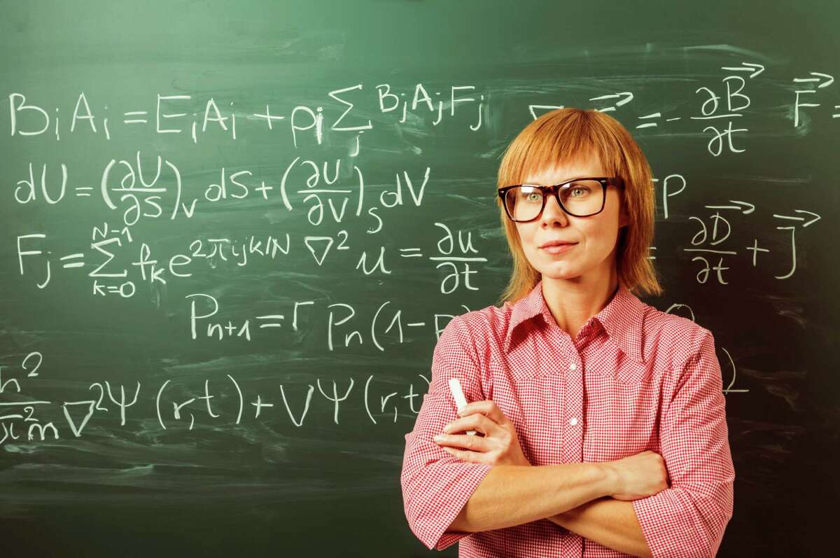 This is teacher. Woman physicist. Dating mathematician. Physics teacher at the blackboard. Professor with Glasses looking Mathematics problem on blackboard.