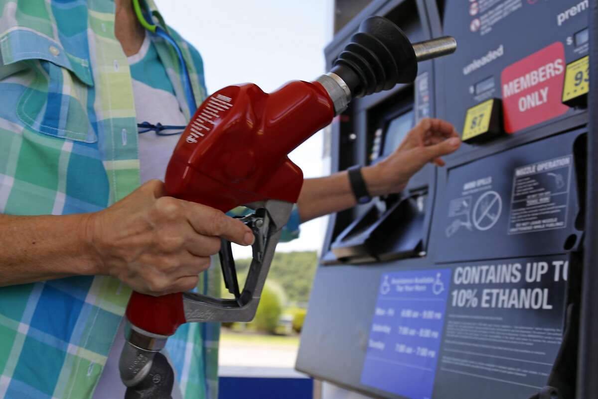 FILE - In this July 16, 2015, photo, a customer refuels her car at a Costco in Pittsburgh. U.S. consumer prices rose modestly in October, 2015 as low gasoline costs and a strong dollar have suppressed inflation. The Labor Department says the consumer price index rose 0.2 percent last month after falling in September and August. Gas costs increased 0.4 percent in October but have plunged 27.8 percent over the past 12 months. (AP Photo/Gene J. Puskar)