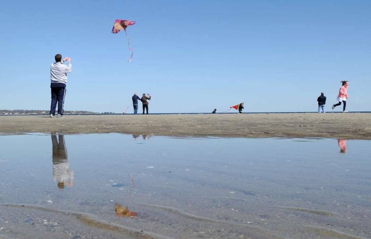 Jeff Seigel, left, of Briarcliff Manor, N.Y., launches his kite into a cloudless blue sky at Greenwich Point during the annual Kite Flying Festival, Saturday afternoon, April 10, 2010, Greenwich, Conn. Seigel said he came into town especially for the festival.