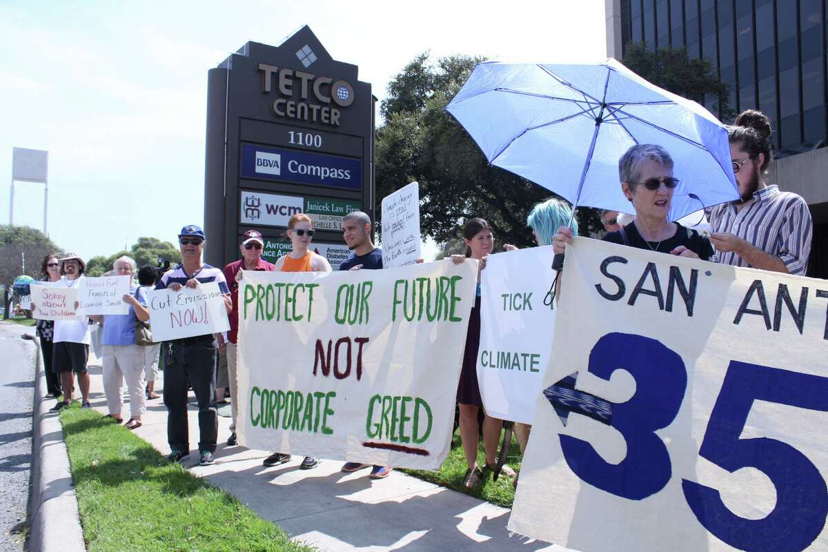 Protestors gather outside the San Antonio office of U.S. Rep. Lamar Smith on Tuesday to call attention to his efforts to discredit climate change science.