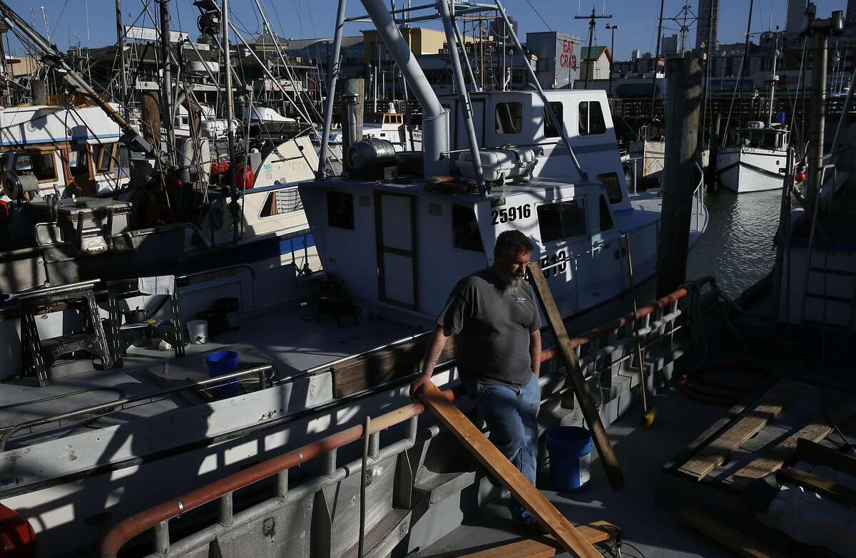 Mike Phillips, 49, pauses while working on sanding down replacement wood planks for his fish bin on his boat, the Miss Alison near Pier 45 in Fisherman's Wharf March 15, 2016 in San Francisco, Calif. Phillips is a third generation fisherman and has been doing it for 38 years. He just bought a house which he saved twenty years for and after having no crab season, he is concerned about what the upcoming salmon season.