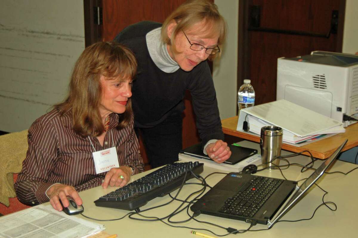 Volunteers, from left, Jayne Day and Ellie MacDowell look over the computer program they use to help people prepare their taxes.