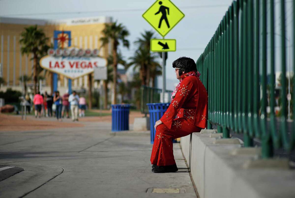 Ted Payne takes a break from working for tips near the "Welcome to Las Vegas" sign. Payne says business has slowed dramatically. ﻿