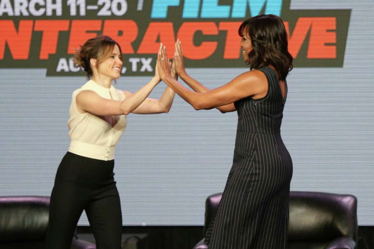 Actress Sophia Bush, left, and first lady Michelle Obama high-five at a panel discussion during South By Southwest at the Austin Convention Center on Wednesday, March 16, 2016, in Austin.