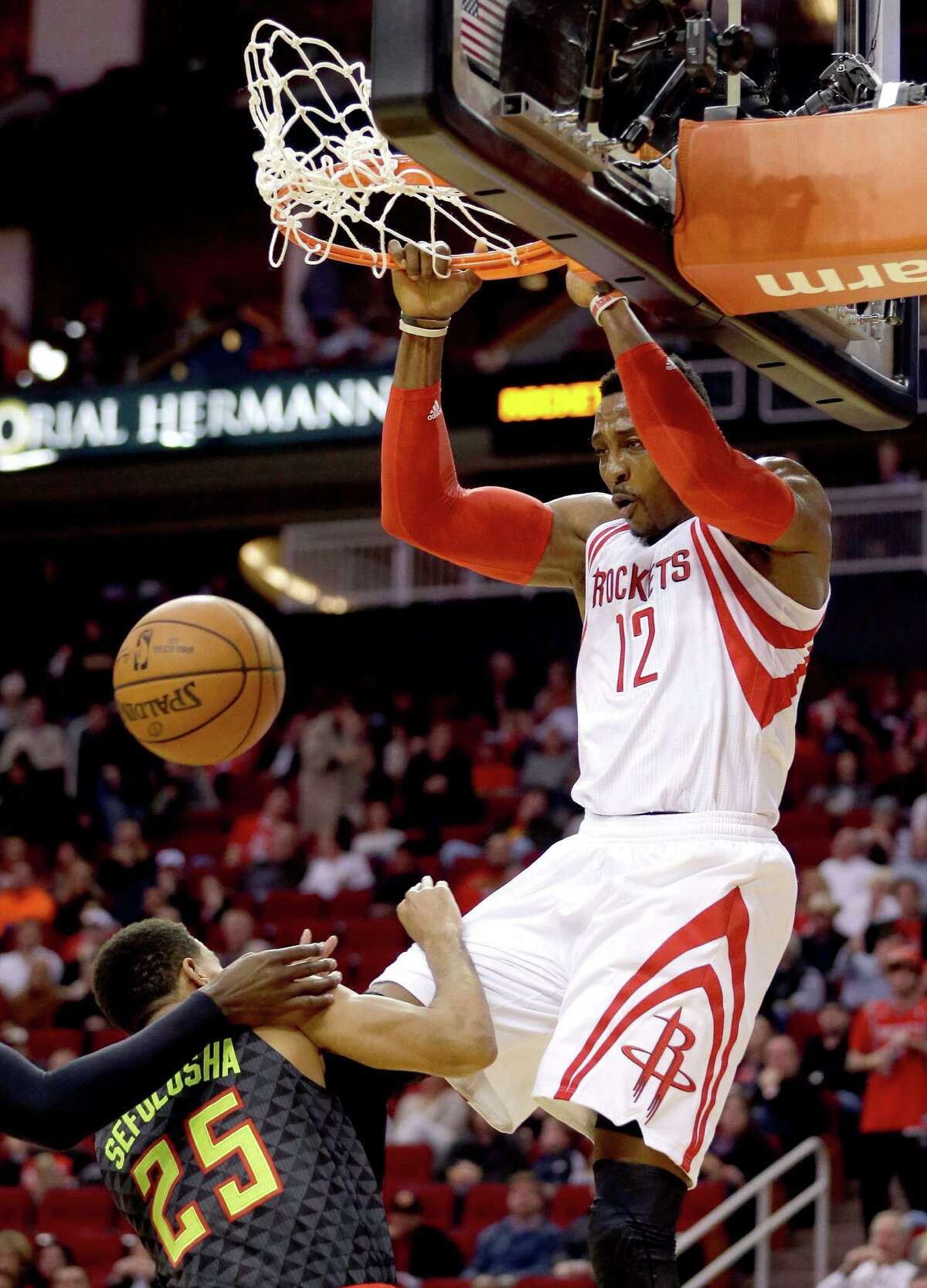 FILE - In this Dec. 29, 2015, file photo, Houston Rockets' Dwight Howard (12) dunks the ball as Atlanta Hawks' Thabo Sefolosha (25) tries to move out of the way during the first quarter of an NBA basketball game, in Houston. Rockets general manager Daryl Morey has always been one of the most aggressive dealmakers in the league, and with Howard having the ability to become a free agent this summer, it might be time to part ways.(AP Photo/David J. Phillip, File)