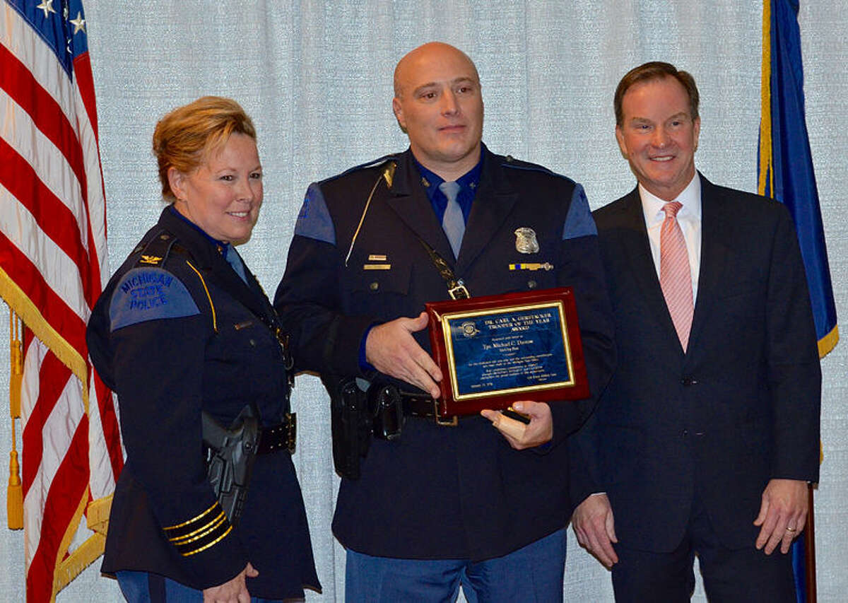 Michigan Attorney General Bill Schuette, right, and Michigan State Police Director Colonel Kriste Kibbey Etue, left, today presented the Gerstacker Trooper of the Year Award to Michigan State Police Trooper Michael Darrow of the Tri-City Post in Bay City.