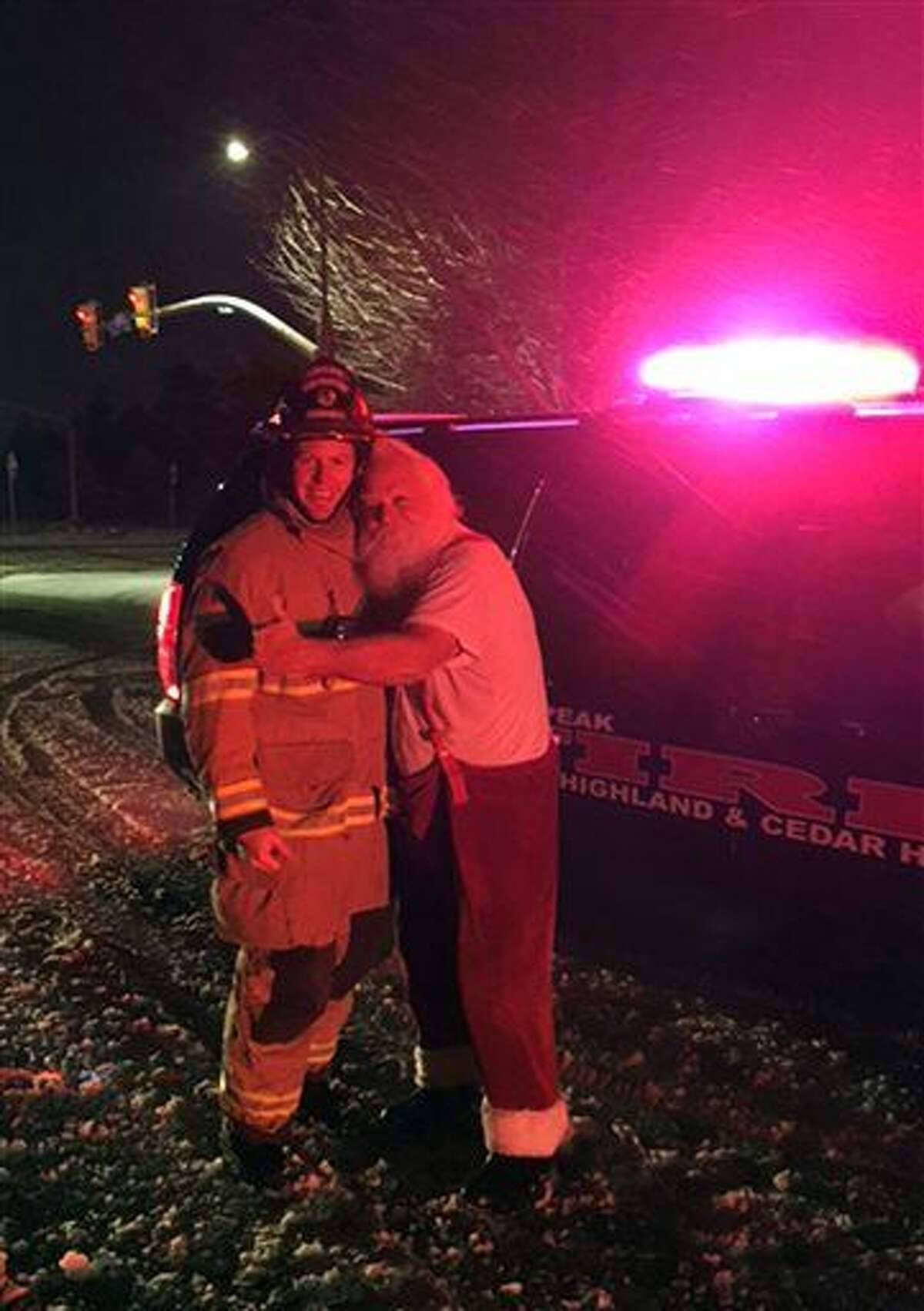 Steven Macey, right, a Santa-for-hire, from Orem, Utah gives a big hug to firefighter Capt. Danny Campbell after fire crews extinguished a fire on Macey’s vehicle on Friday, Dec. 25, 2015 near Alpine, Utah. Firefighters called to the car fire in the Utah suburb got a big surprise early Christmas morning when they discovered the stranded driver turned out to be Santa Claus on the way to deliver presents. (Lt. Dustin Mitchell/Lone Peak Fire District via AP)