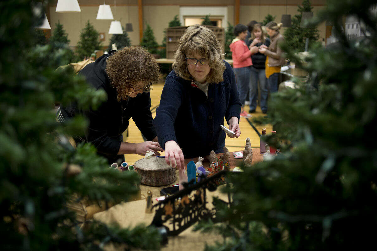 Tanya Searle, left, and Lisa Kempf, both of Midland, set-up nativity scenes from different countries inside the Church of Jesus Christ of Latter-day Saints Wednesday morning.