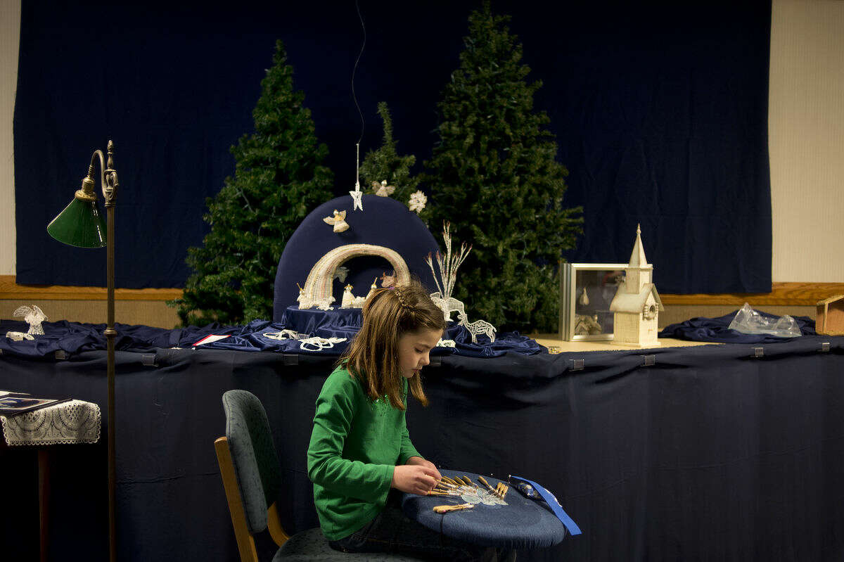 Nine-year-old Margaret Lowe of Midland, works on making a lace angel to go with the Mid Michigan Lace Markers nativity scene inside the Church of Jesus Christ of Latter-day Saints Wednesday morning.