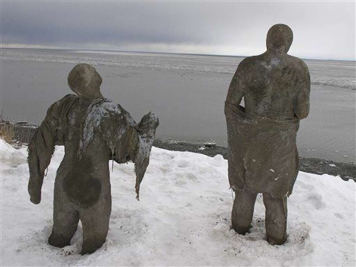Sculptures made of straw, cement, plaster and burlap are part of a public art installation Tuesday, Nov. 24, 2015, at Point Woronzof in Anchorage, Alaska. Lead project artist Sarah Davies says the display of 85 sculptures will officially open Dec. 5 and represents people dealing with emotional vulnerabilities, including trauma and mental illness. (AP Photo/Rachel D'Oro)