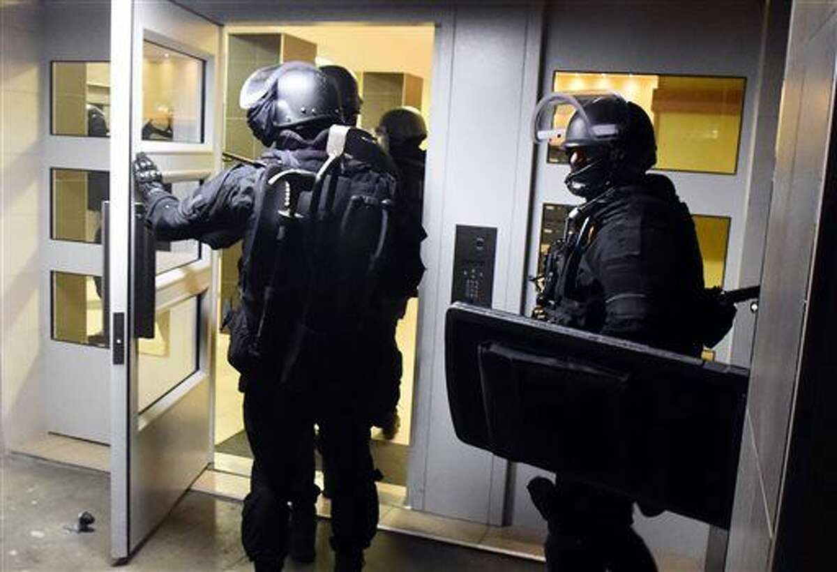 Anti terrorism police officers enter a building during a raid in the Mirail district in Toulouse, southwestern France Monday. France's Prime Minister Manuel Valls says there have been 150 police raids overnight in the country. 