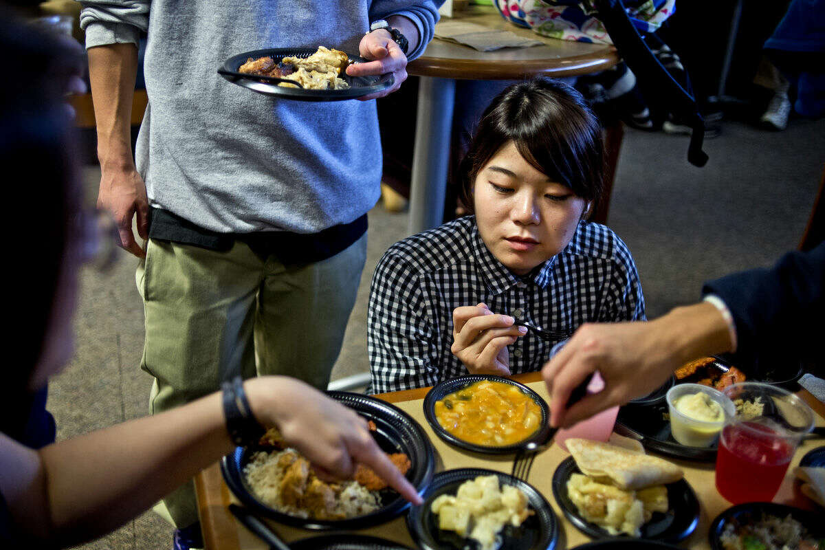 Saginaw Valley State international student Nanami Ootani, who hails from Japan, samples various dishes during the annual International Food Festival hosted by the Saginaw Valley State University International Student Club on Tuesday.