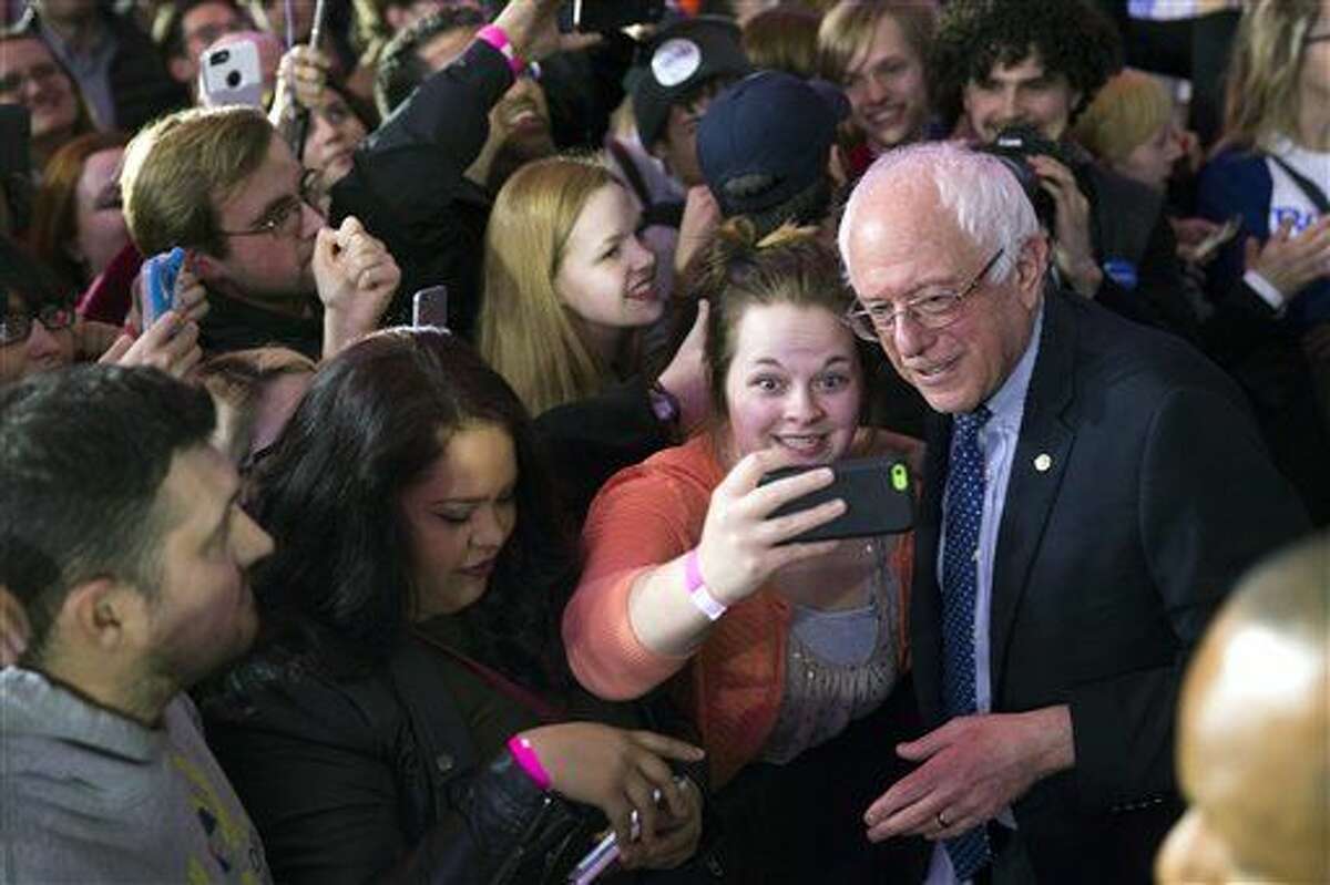 Democratic presidential candidate Sen. Bernie Sanders, I-Vt., poses for photos during a caucus night rally on Monday, Feb. 1, 2016, in Des Moines, Iowa. (AP Photo/Evan Vucci)
