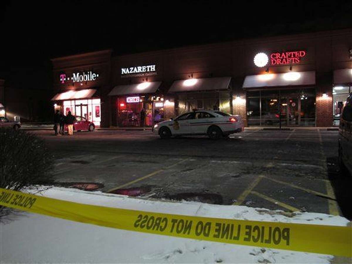 Unos hombres caminan afuera del restaurante en Columbus, Ohio, donde dice la policía que un hombre atacó a varias personas con un machete el jueves 11 de febrero de 2016. Autoridades dicen que el hombre huyó del lugar y posteriormente murió por disparos de la policía. (Foto AP/Kantele Franko)