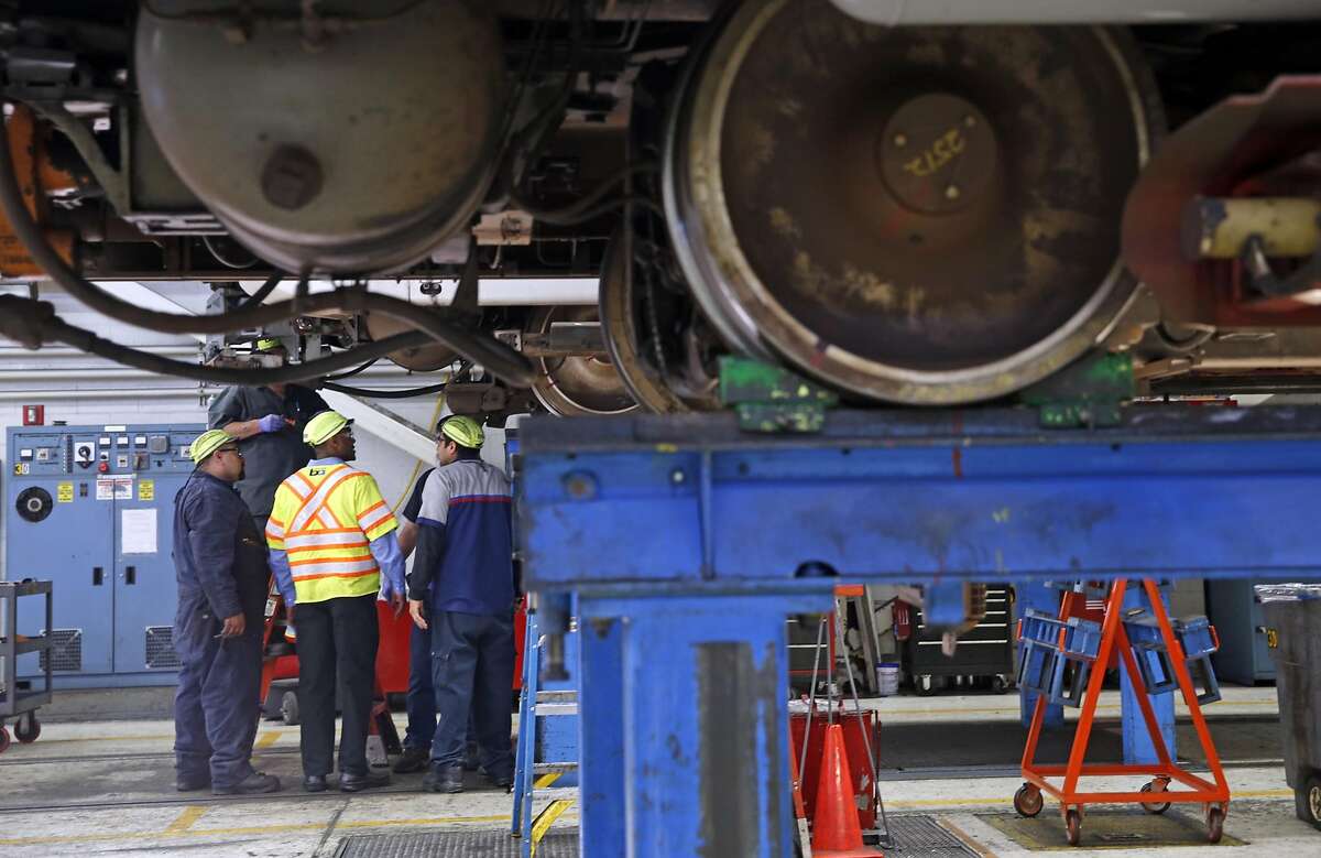 Workers inspect a train at the BART maintenance facility in Concord, Calif., on Thursday, March 17, 2016.