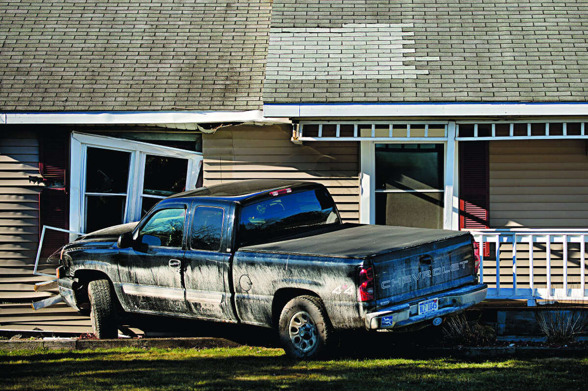 No one hurt when truck goes off road, strikes house