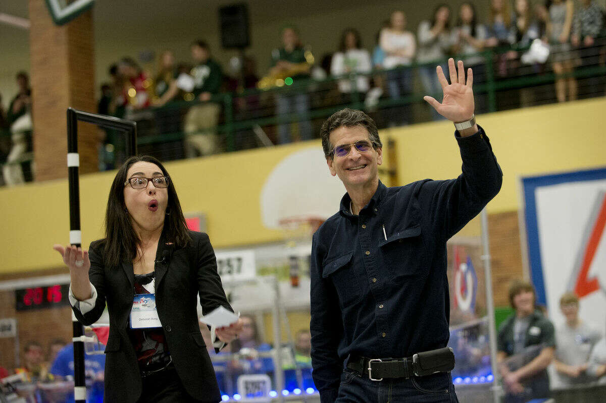 Dean Kamen, founder of FIRST, waves as Deborah Borg, president, Dow USA, pumps up the crowd at the Great Lakes Bay Region FIRST Robotics District Competition at H.H. Dow High School before the announcement that Dow Chemical is becoming a strategic partner with FIRST. Dow has made a $1 million commitment to FIRST over the next two years.