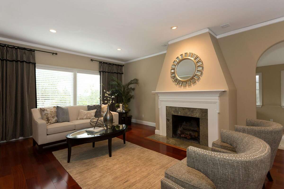A wood-burning fireplace with stone surround anchors a living room with Brazilian hardwood flooring.