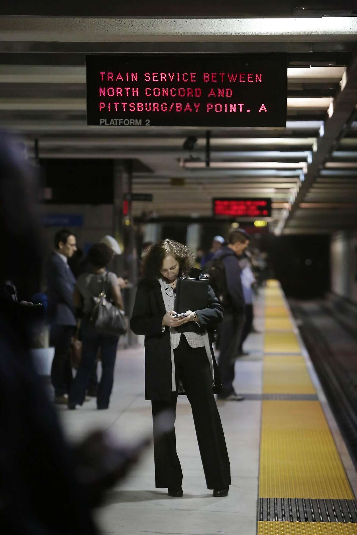 Jenny Wodinsky of Orinda stands under a sign alerting riders to a bus bridge between the North Concord and Pittburgh/Bay Point station as she waits for the Pittburgh/Bay Point Bart train at Embarcadero Station on Friday, March 18, 2016 in San Francisco, California.