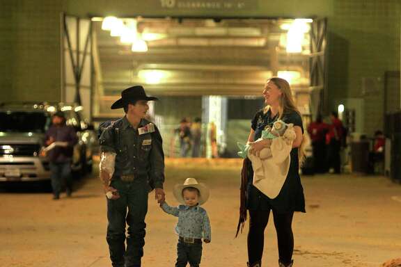 Bareback rider Ryan Gray leaves NRG Stadium with his two-year-old son Ransom, his wife Lacy, and their one-month-old daughter Laramie after the rodeo, Tuesday, March 15, 2016, in Houston.