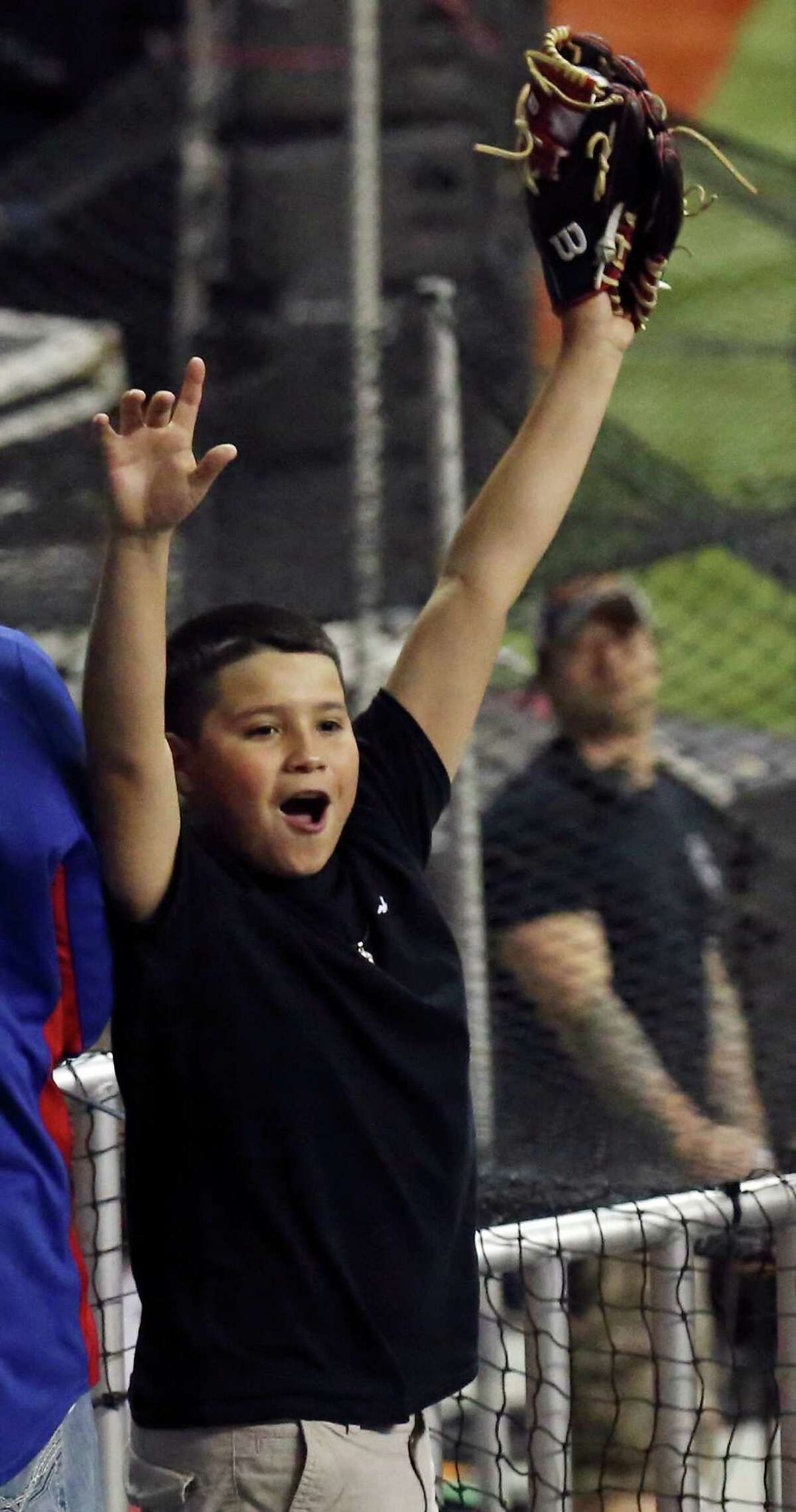 Texas Rangers fan Brandon Garcia, 14, celebrates after catching a ball hit into the stands during batting practice before the Rangers and Kansas City Royals Big League Weekend spring exhibition baseball game Friday March 18, 2016 at the Alamodome.