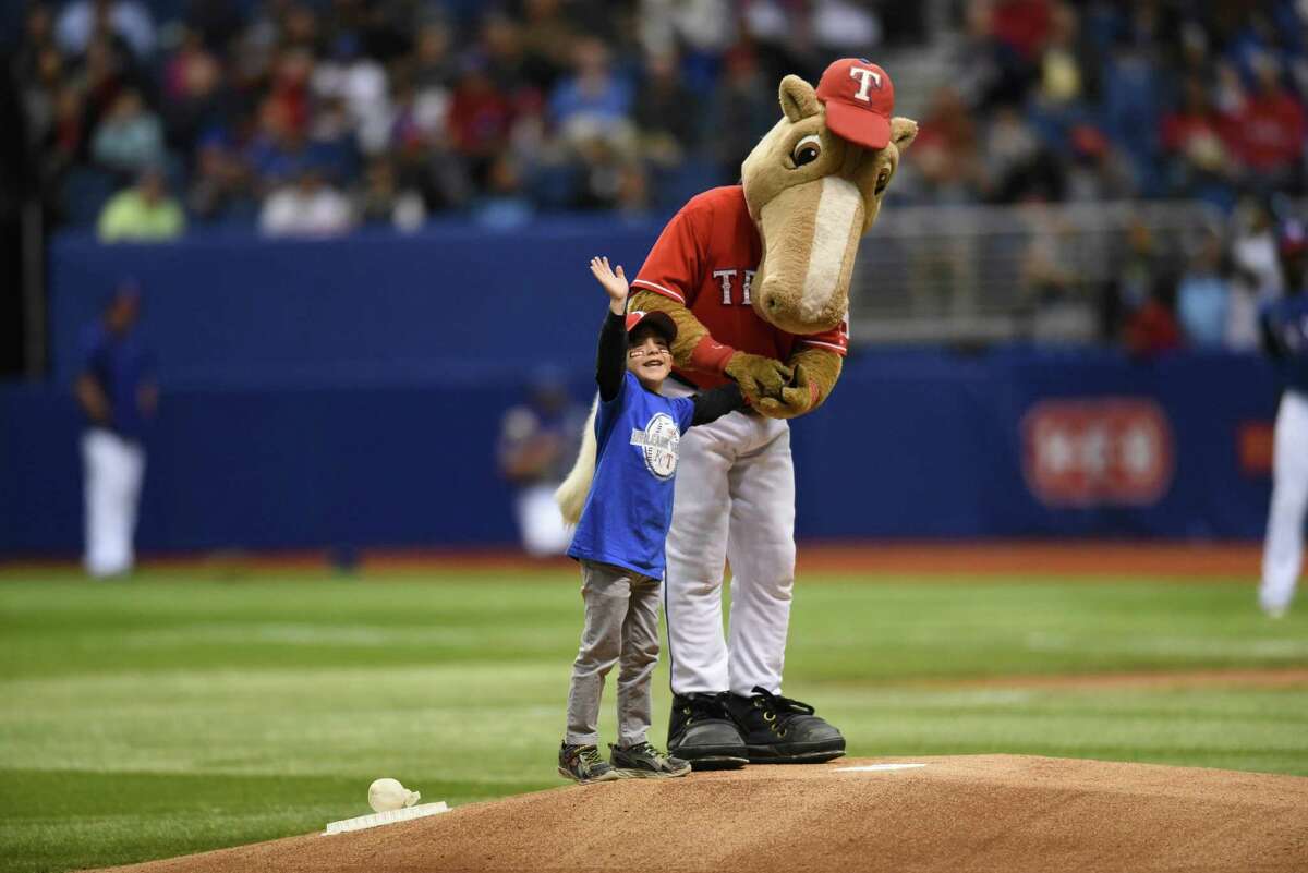Christopher Gonzalez of San Antonio delivers the game ball to the Texas Rangers mascot, Rangers Captain, during Big League Weekend action at the Alamodome on March 19, 2016.