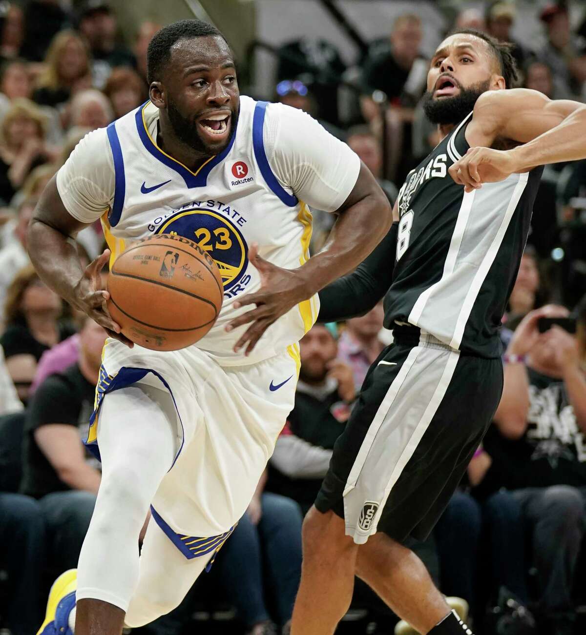 Golden State Warriors' Draymond Green (23) drives around San Antonio Spurs' Patty Mills during the first half of Game 4 of a first-round NBA basketball playoff series in San Antonio, Sunday, April 22, 2018, in San Antonio. (AP Photo/Darren Abate)