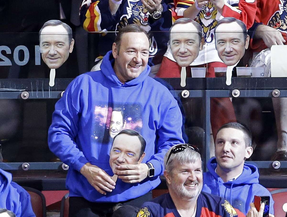 Actor Kevin Spacey smiles as he acknowledges the fans as he hold a mask during an NHL hockey game between the Florida Panthers and the Detroit Red Wings in Sunrise, Fla., Saturday, March 19, 2016. (AP Photo/Alan Diaz)