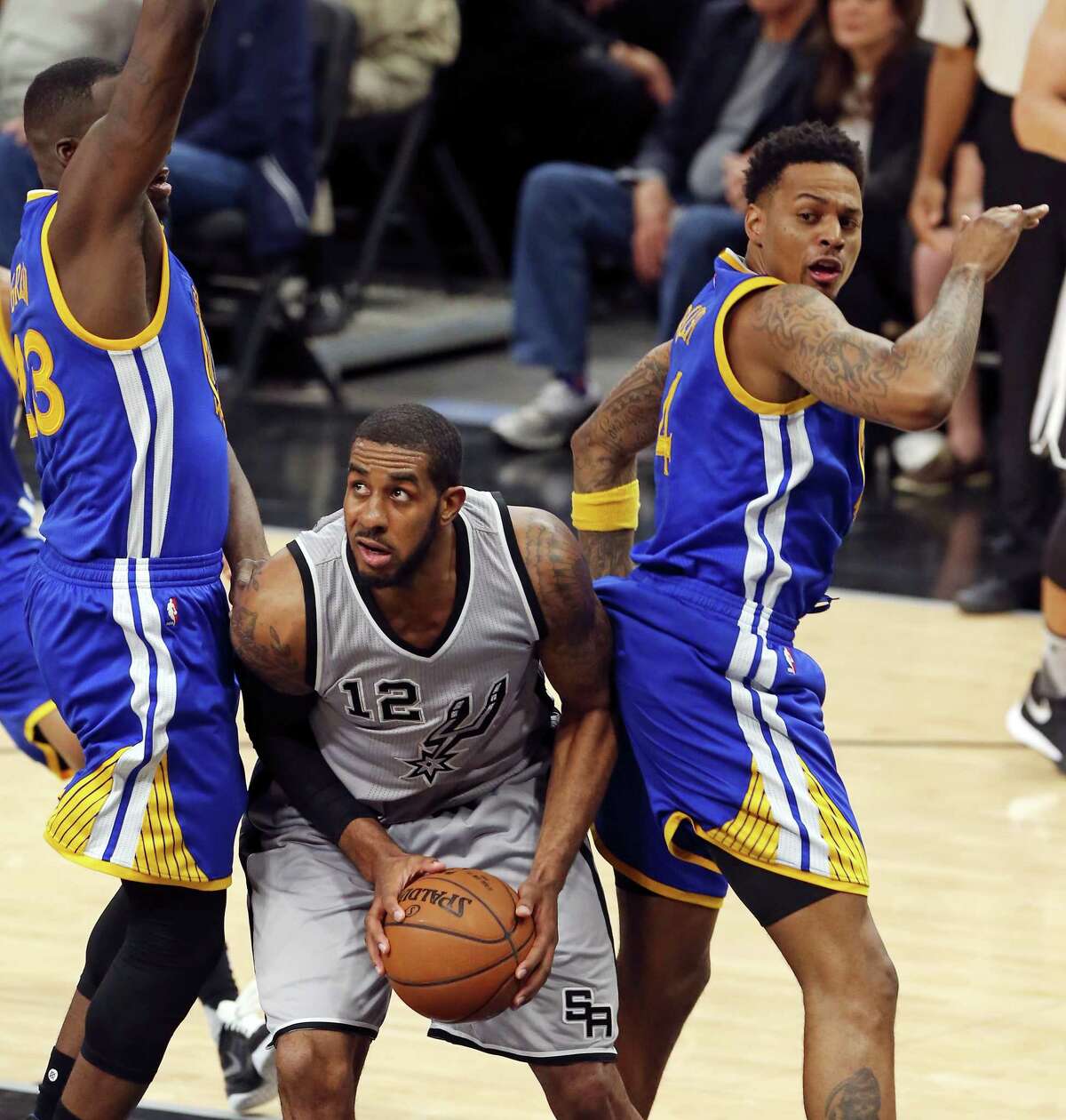 San Antonio Spurs' LaMarcus Aldridge looks for room between Golden State Warriors' Draymond Green (left) and Golden State Warriors' Brandon Rush during first half action Saturday March 19, 2016 at the AT&T Center.