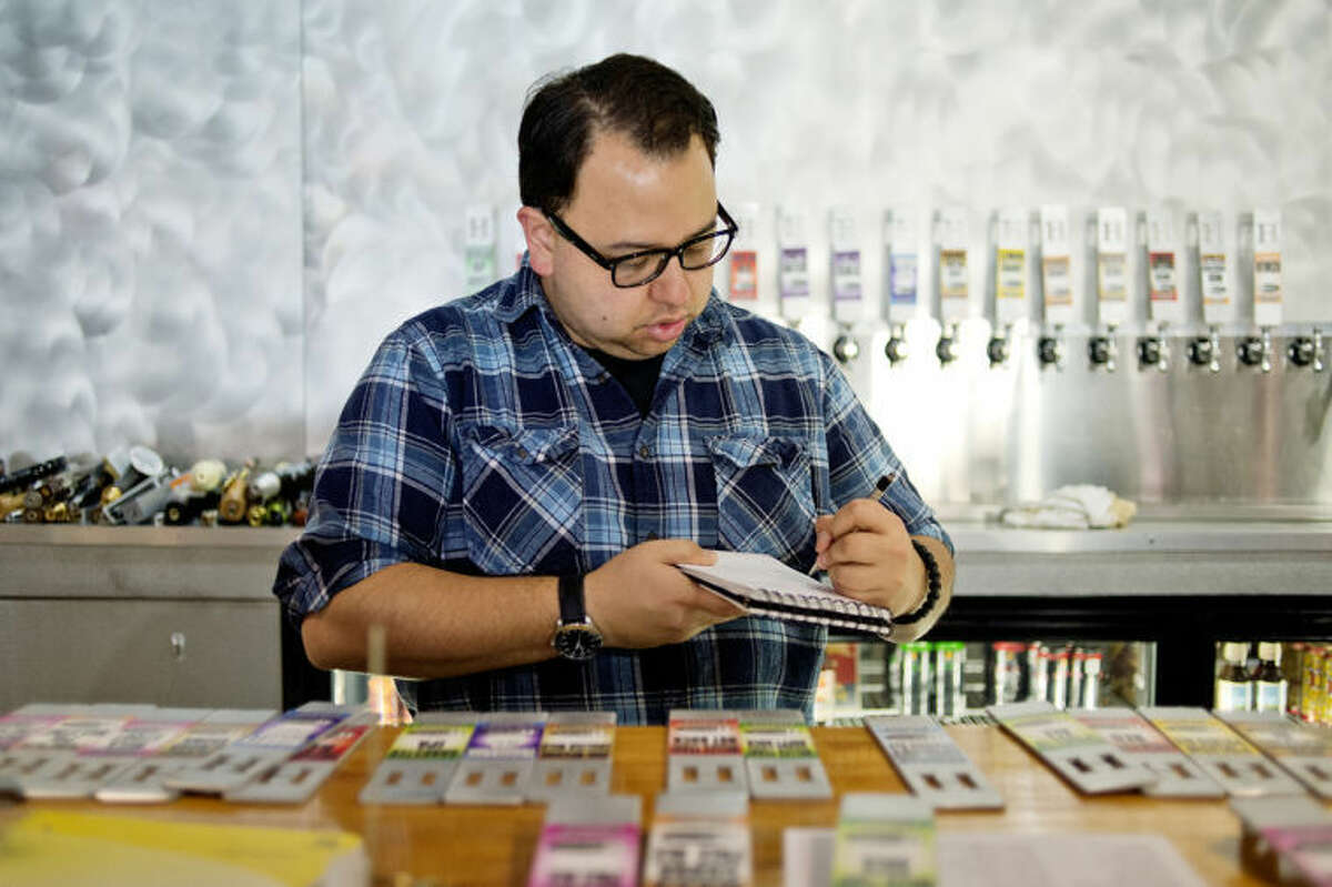 NICK KING | nking@mdn.netManager Russell Kela organizes tap handles at WhichCraft Taproom as he and other employees prepared for a recent tap takeover.