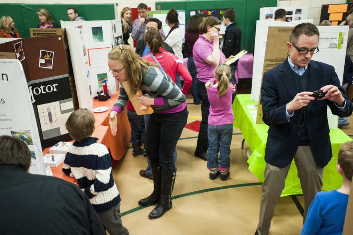 ZACK WITTMAN | for the Daily NewsJudges wander around the gymnasium while parents take photos of their young scientists during Siebert Elementary School's annual science fair.