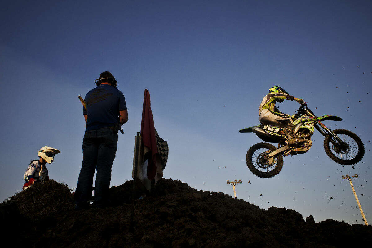 Brian Playter, of Hudsonville, right, and Isaac Hetherson, of Hope take a jump Friday during the Super Cross event at the Midland County Fair.