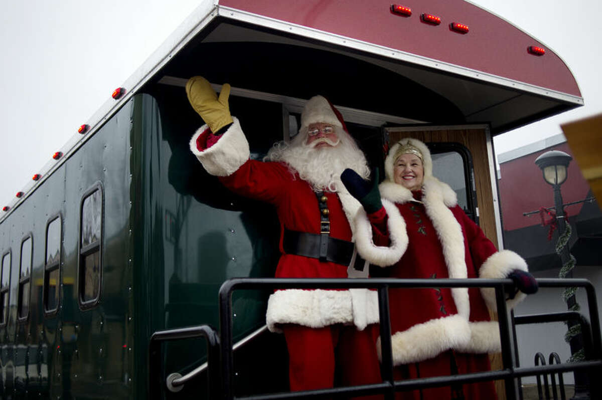 Santa and Mrs. Claus, on the Northern Star train, wave to parade attendees during the Santa Parade on Saturday in downtown Midland.