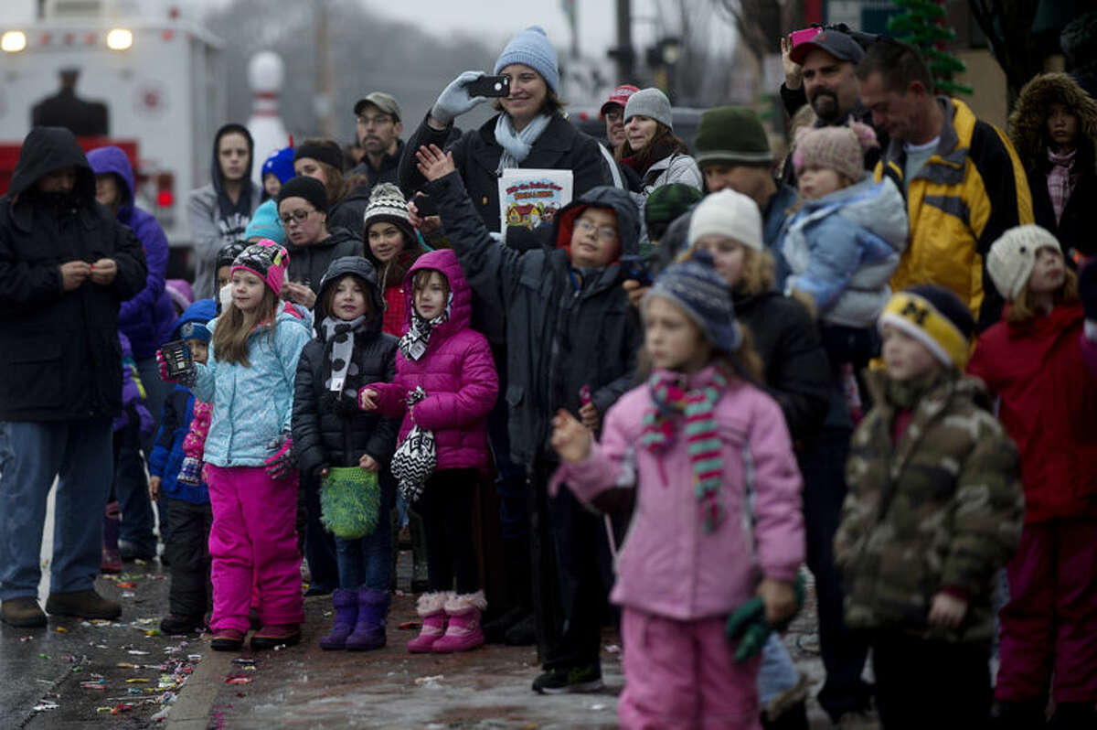  Parade guests watch as Santa and Mrs. Claus make their way along the parade route on Ashman Street on Saturday.