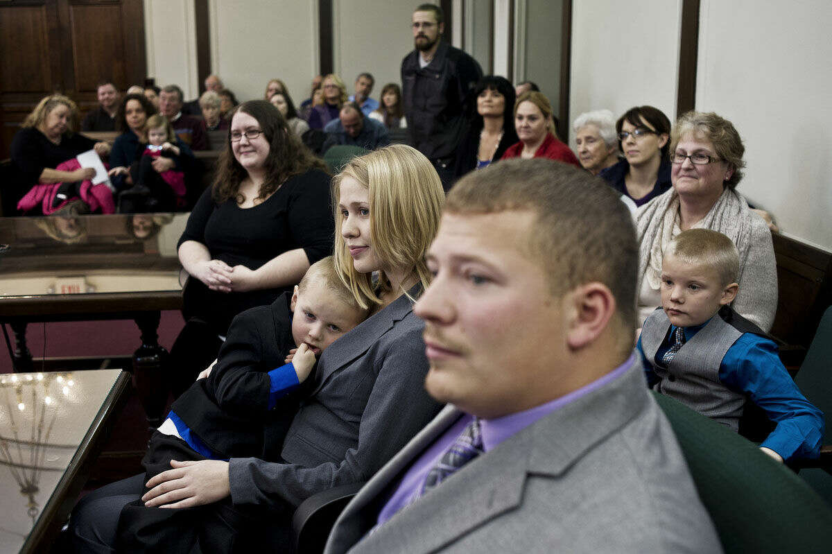Keygann Cripps, 4, rests on the lap of Beth Hartnagle as she and her fiancé, Cory Cripps, listen to Judge Dorene Allen as she officially announces Keygann's adoption on Tuesday morning during Adoption Day at the Midland County Courthouse.