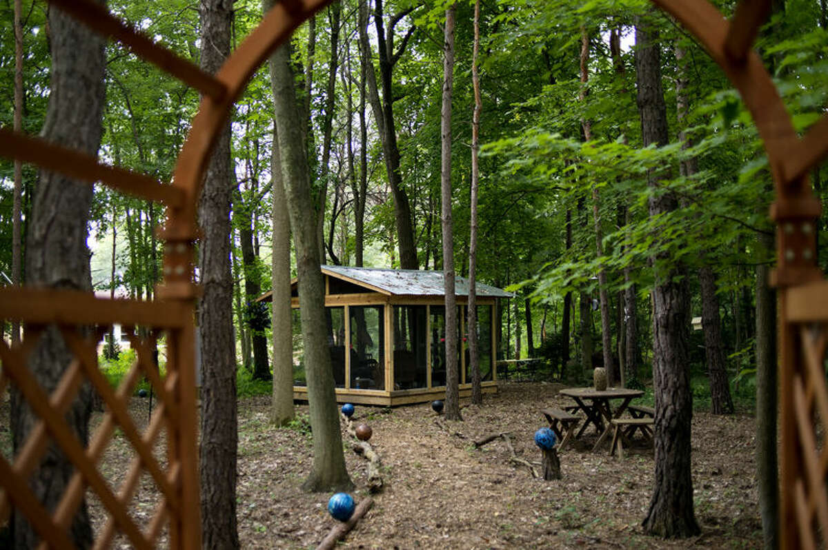 A trail lined with bowling balls leads to the couple's screened porch on their Midland property.
