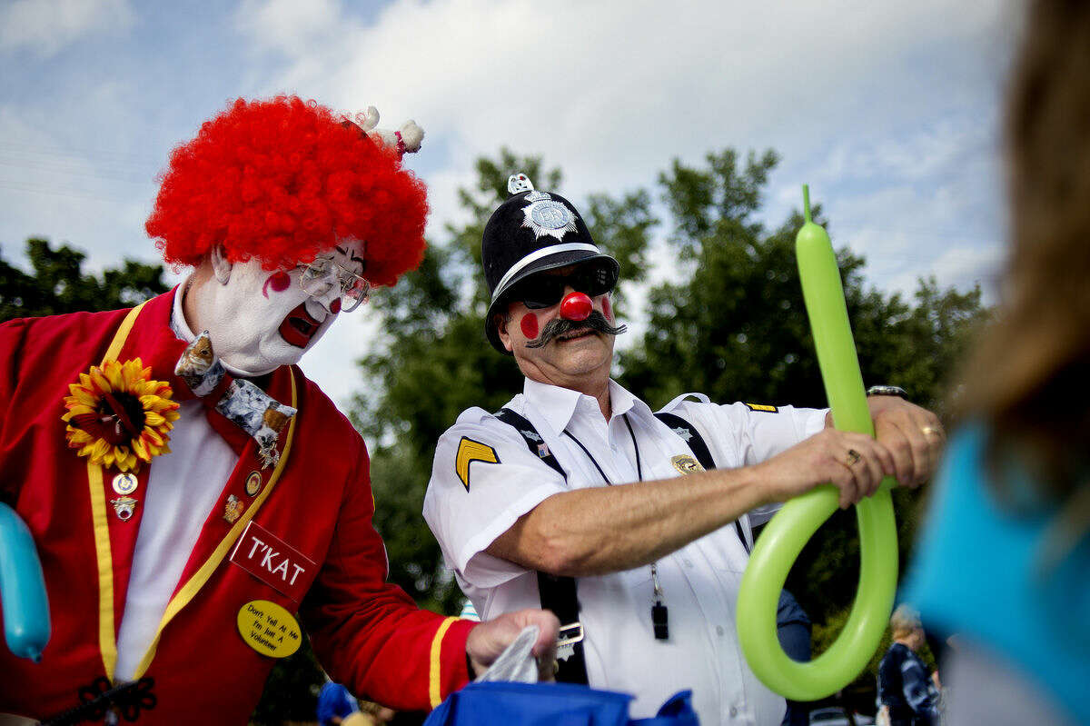 Clowns T'Kat, left, and Sergeant Do-Right make balloon animals for patrons during a neighborhood party and 25th anniversary celebration on Saturday at New Life Vineyard Church in Midland. The free event, which was open to all, featured carnival games, food and live music.