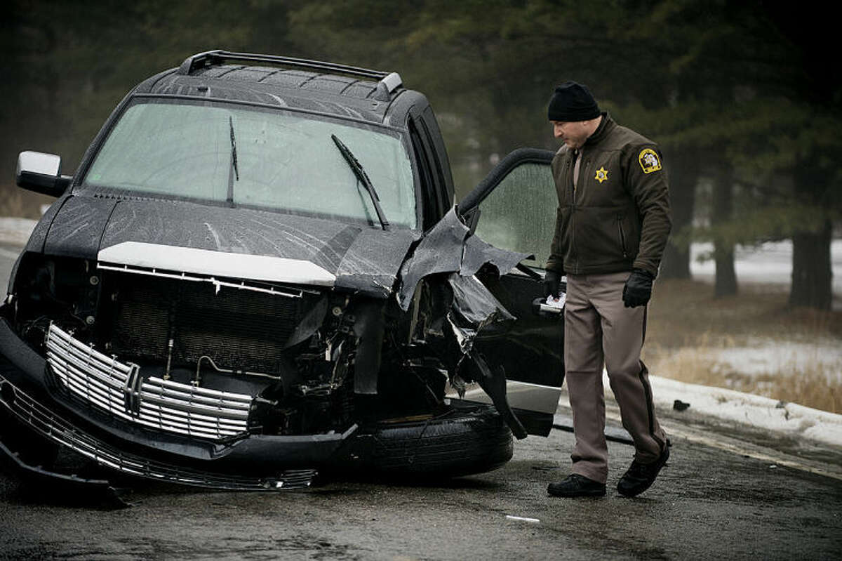 NEIL BLAKE | nblake@mdn.netMidland County Sheriff Scott Stephenson looks at a Lincoln Navigator that was involved in an accident with a liquid propane tanker truck on South Eight Mile and Stewart Road. The accident caused the evacuation of some residents on Tuesday.