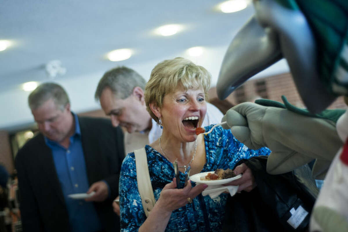 ZACK WITTMAN | for the Daily NewsLou. E. Loon feeds Midland resident Marilyn Zank a tomato during the Shelterhouse fundraiser at the Midland Center for the Arts on Thursday. "Oh I love coming here," Zank said. "The foods, friends and wine, it's all great."